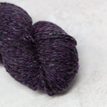 Close up of purply yarn with flecks of colours