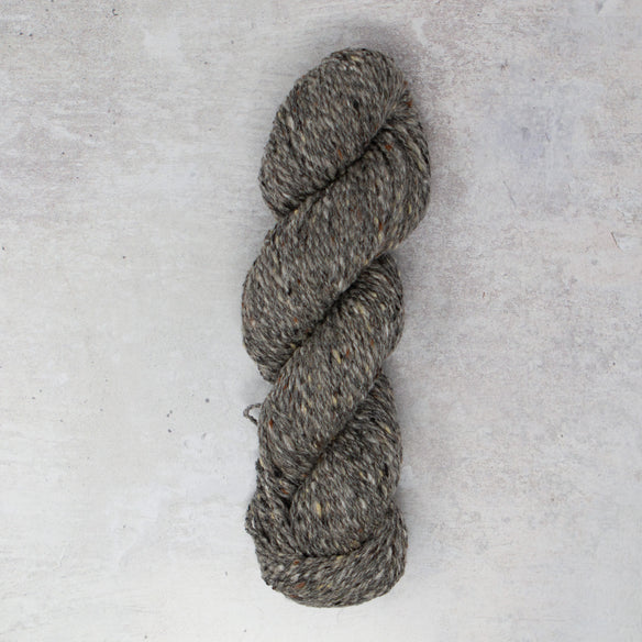 hands wrapping two skeins of yarn in brown paper